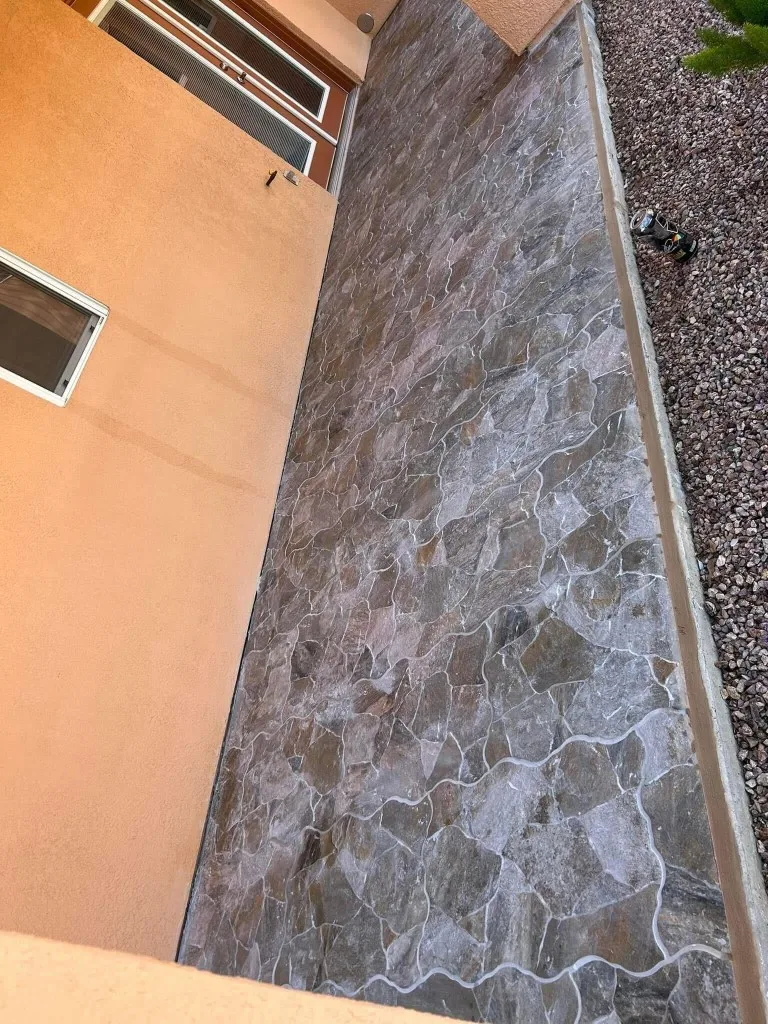 Outdoor flagstone patio walkway with natural stone pavers and decorative gravel border