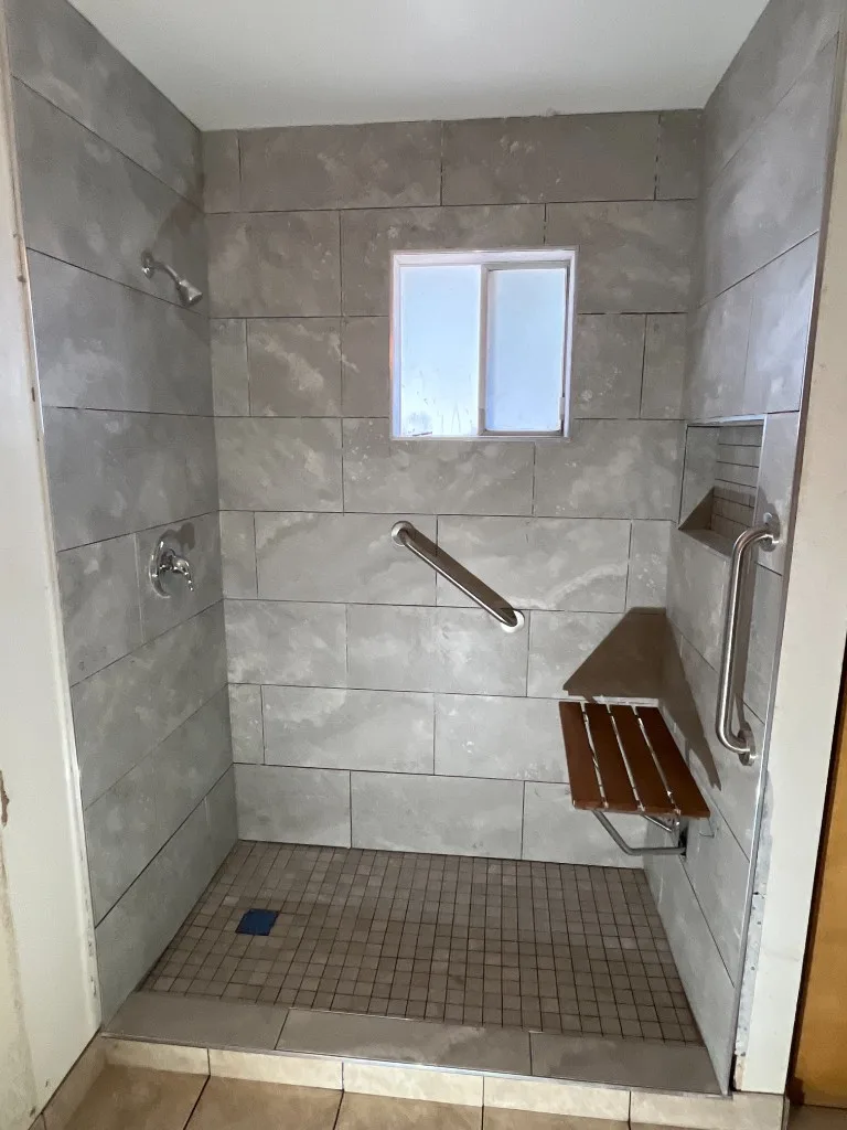 Walk-in shower tile with mosaic floor and bench