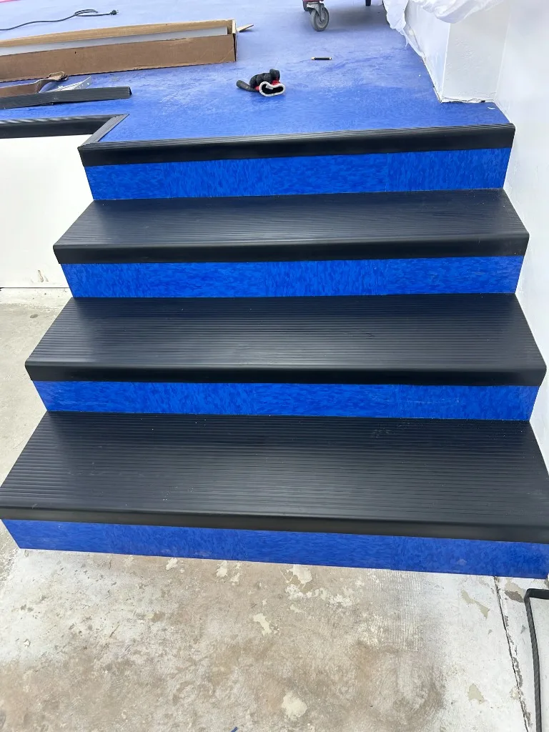 Stair risers finished with blue vinyl tile and rubber treads
